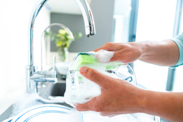 istock Woman washing a drinking glass with a sponge 1482591294