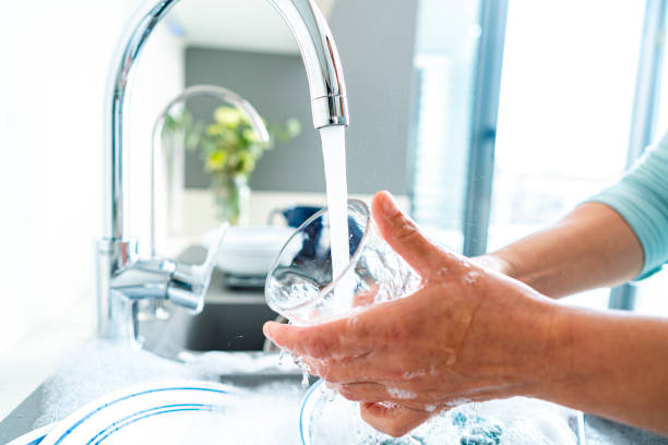 istock Woman washing a drinking glass under running water 1482591295