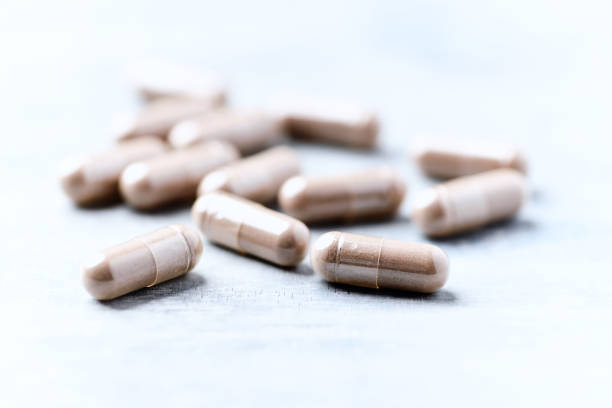 istock Guarana capsules. Bright wooden background. Close up. Copy space. 1482592024