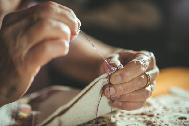 Close up of an elderly woman sewing
