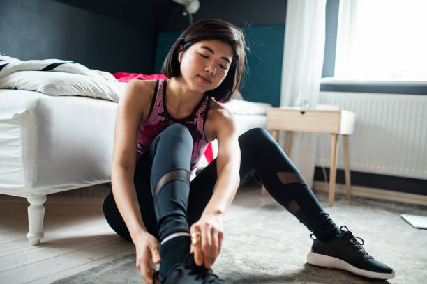 istock Young woman tying her shoelaces and getting ready to go exercise 1482598324