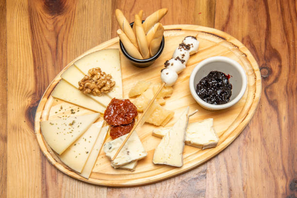 istock Typical table of assorted cheeses viewed from above with dried tomato, jam, walnuts and bread spikes 1482602231