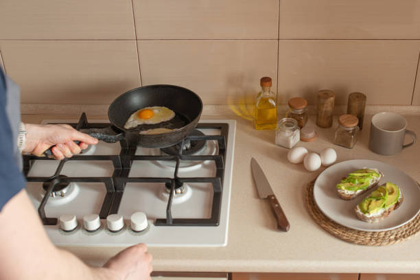 istock Young man preparing toast with avocado and egg for breakfast in the kitchen 1482603845