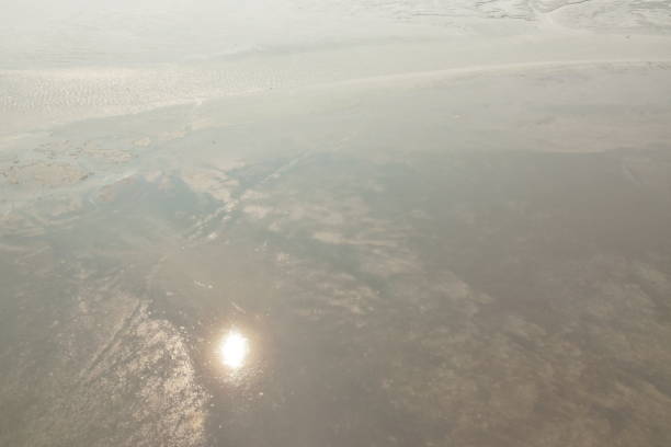 reflection of sun on mud and sand in low tide sea on Thailand