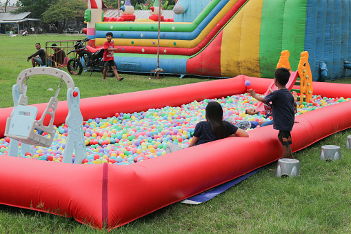 Cilacap, Indonesia March 14, 2023 : a few young children playing a ball pool game in the city park with their parents.