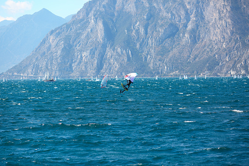 Lake Garda - April 3: windsurfers on the mountain Lake Garda in Italy on the April 3, 2023 . This lake is a famous  place for windsurfers.