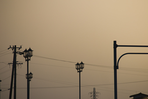 Yellow hazy sky with yellow dust and silhouette of electric wires Environmental pollution