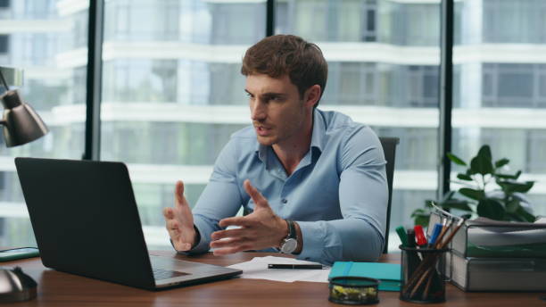 istock Man conducting education webinar using laptop in office close up. Online meeting 1482614999