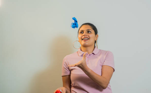 college student with colored papers on gray background, young woman playing and interacting with colored papers.