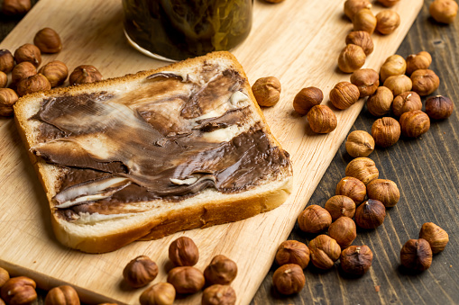 slices of bread with chocolate butter on the table, cooking a simple homemade sweet dessert using chocolate butter with white bread