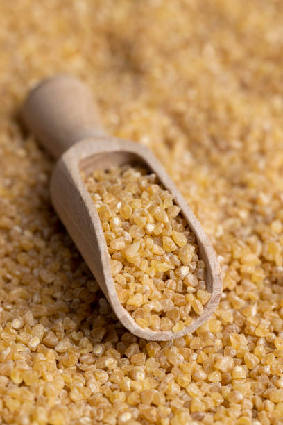 istock Not cooked wheat porridge with a wooden spoon 1482619527