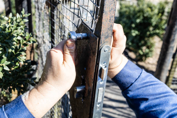 istock worker mounts new door lock in iron gate close up 1482621098