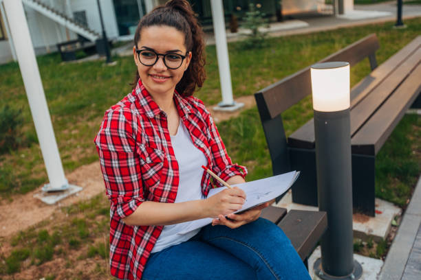 istock A young woman is drawing while she is sitting on the bench 1482622402