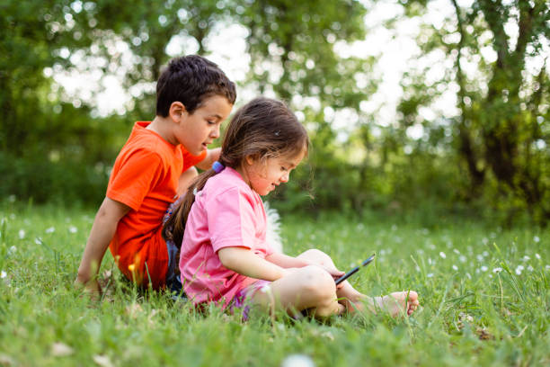 istock Children  playing on tablet in nature 1482627537