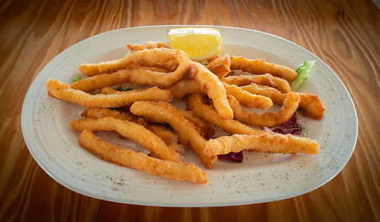 Portion of fried squid strips with lemon