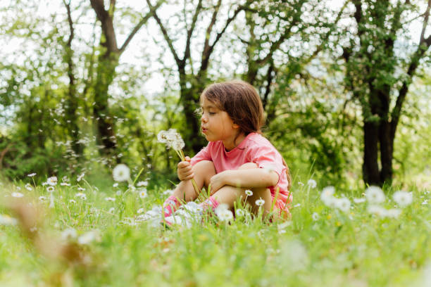 istock Girl blowing dandelion seed 1482627636