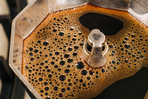 Above close shot of moka pot making espresso coffee on a stove