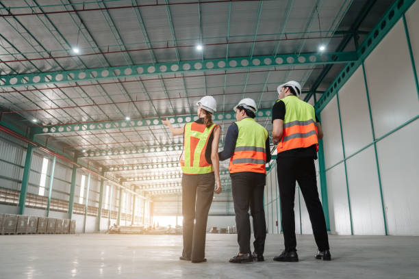 istock Team engineers workers planning and talking in empty warehouse to design the arrangement of product shelves and organize strategy about new manufacturing. 1482629299