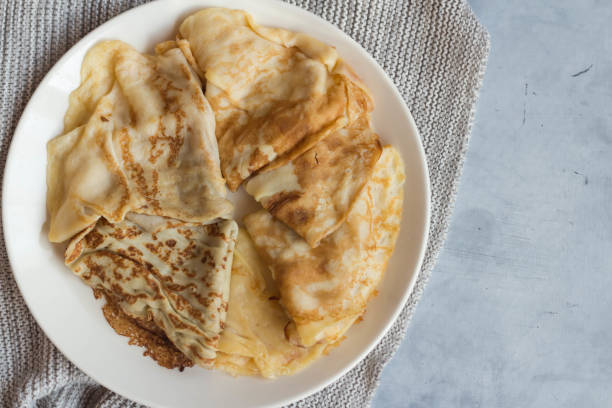 istock Pancakes are on a white plate on a gray knitted fabric, on a gray background. 1482630156