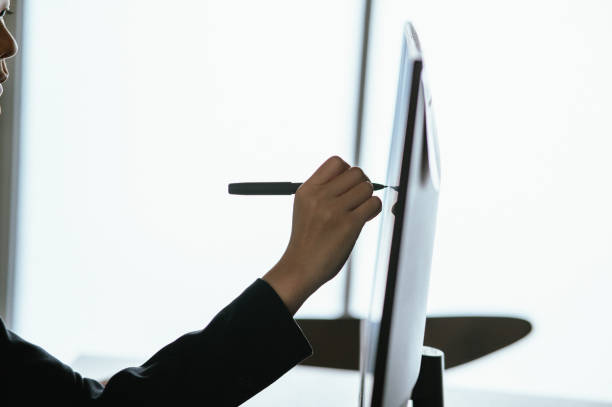Closeup of a woman using smart pen technology for working and writing on digital monitor screen, stock photo