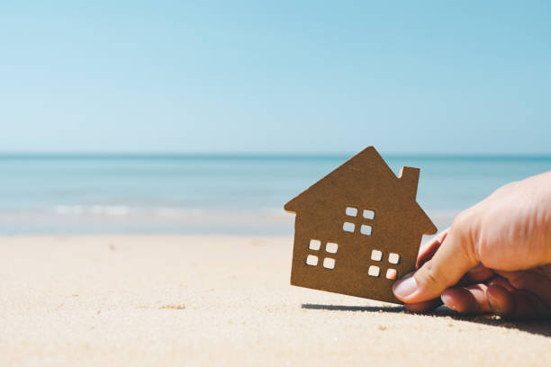 House model in sand , a symbol for construction , ecology, loan, mortgage, property or home, concept for housing problems. stock photo
