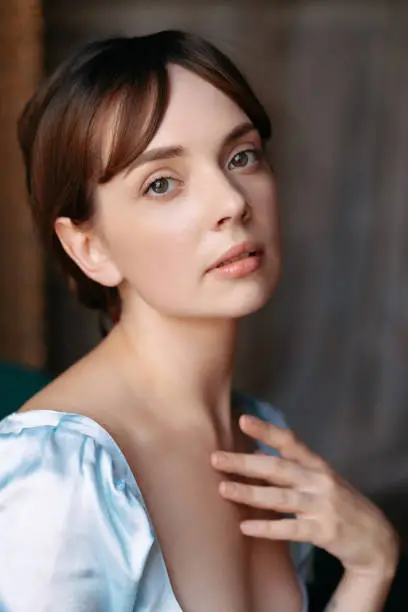 Photo of Portrait of a young beautiful girl in a blue Regency style dress