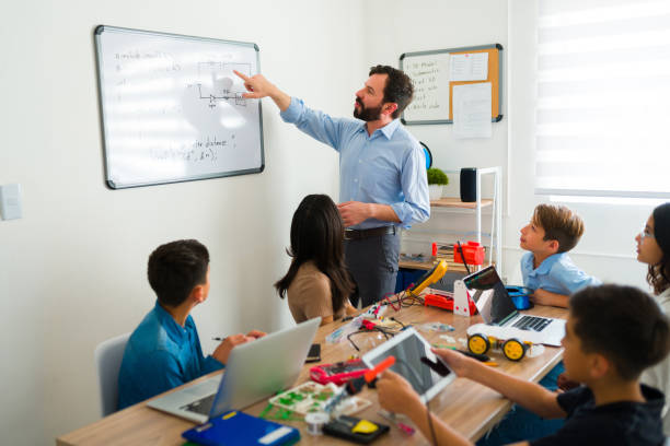 istock Electronics instructor teaching about circuits and robots to their teen students 1482632946
