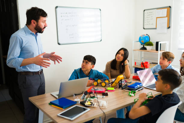istock Smart teens listening to their robotics instructor in class 1482634089