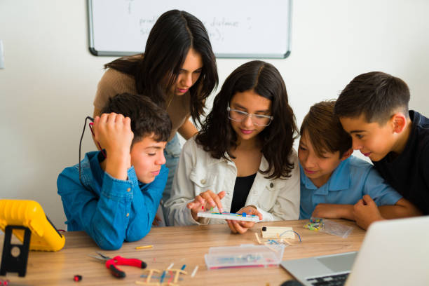 istock Happy smart teen boys and girls learning about electronics circuits 1482634409