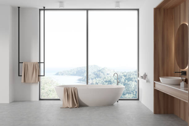 istock Light bathroom interior with sink and mirror, tub near panoramic window 1482635720