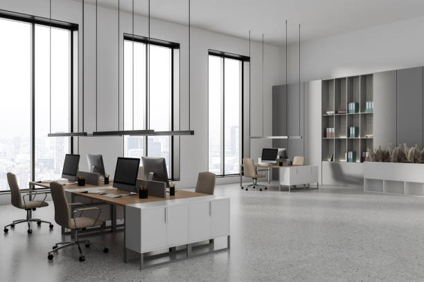 istock Stylish coworking interior with pc computer on desk, shelf and panoramic window 1482635814