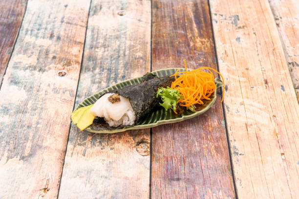 생선알을 곁들인 버터피쉬 테마키 스시, 쌀 식초를 곁들인 밥, 잘 익은 아보카도 조각, 김 콘을 잎 모양의 접시에 담은 요리 - sashimi sushi salad sea 뉴스 사진 이미지