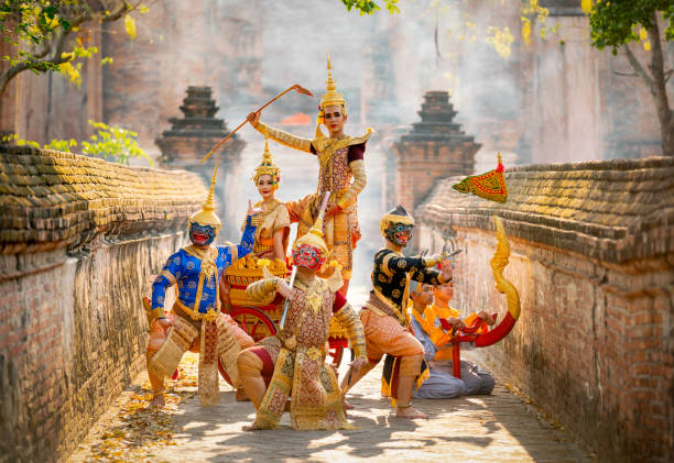 eine gruppe von khon oder traditionellen thailändischen klassikern, die von den ramakien-charakteren maskiert sind, stehen zusammen mit einer aktion des traditionellen tanzes mit einem thailändischen alten gebäude im hintergrund des öffentlichen platze - bangkok thailand asia temple stock-fotos und bilder