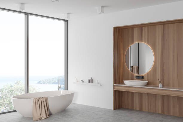 istock Light bathroom interior with sink and mirror, tub near panoramic window. Mockup 1482636085