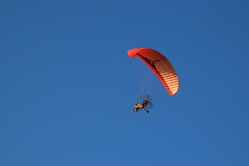 A powered paraglider on a sky background
