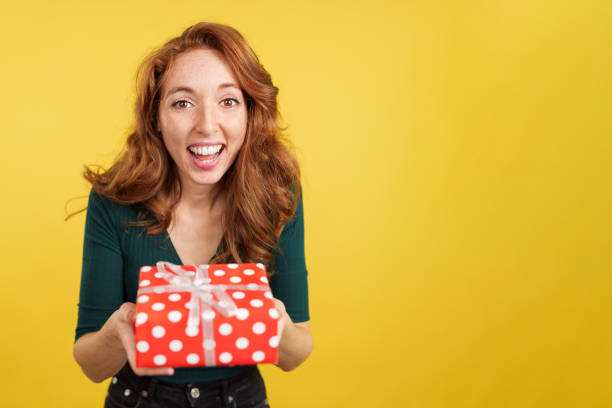 istock Redheaded woman smiling at camera with a gift 1482639753