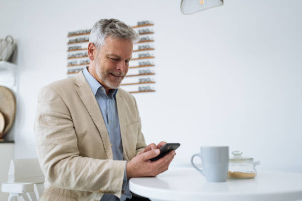 istock Mature businessman in cafe using smart phone and mobile apps 1482643100