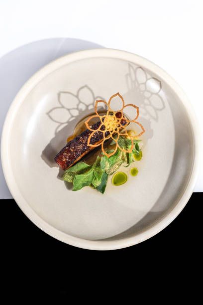 Roast pork belly meat dish with sage butter and dill oil at Michelin star gourmet restaurant stock photo