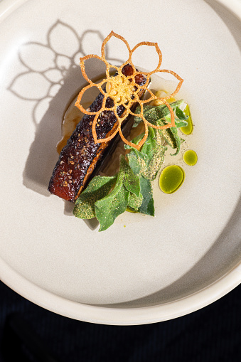 Roast pork belly meat dish with sage butter and dill oil at Michelin star gourmet restaurant