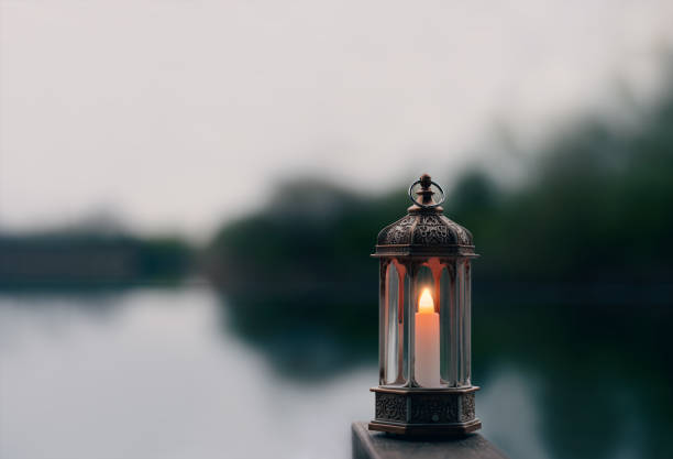 Ramadan Kareem, Arabic lantern with burning candle with blurry natural background.Image for Festive greeting card,invitation for Muslim holy month,Eid Mubarak,Eid al Adha,Eid al Fitr