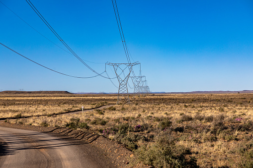 High voltage Electrical pylons in the semi arid Karoo region of South Africa in a diminishing perspective.