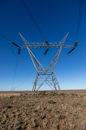Electricity transmission pylons with other pylons and lines running into the distance in the Karoo area of South Africa