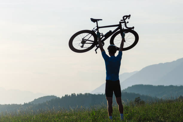 istock Cyclist rising a bicycle above his head and looking at sunset 1482650260