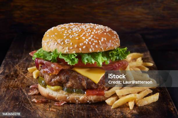 Juicy Ground Pork And Bacon Cheeseburger With Fries Stock Photo - Download Image Now