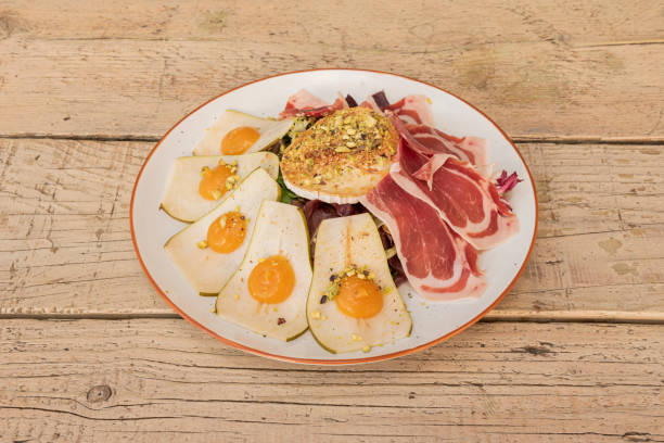 istock Goat cheese salad with serrano ham, lettuce, pear slices 1482651895