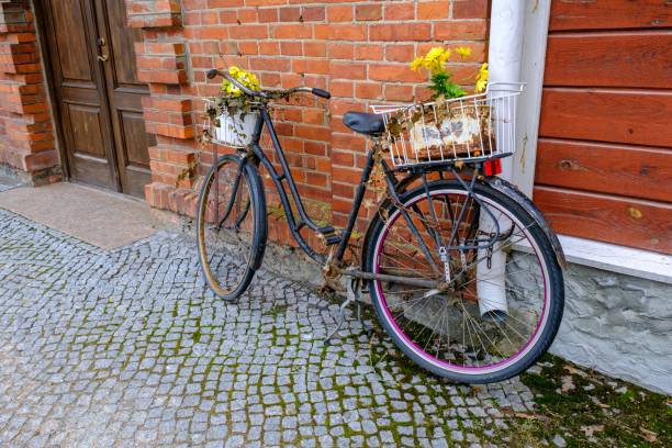 istock old rusty bicycle with old withered flowers near red brick building. 1482659292