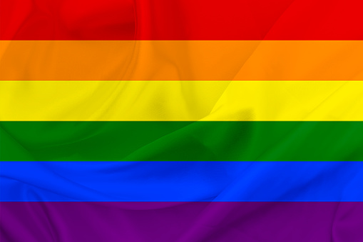 A rainbow flag background. LGBT