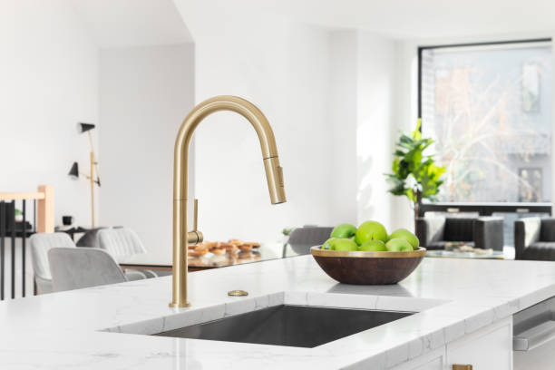 istock A gold faucet detail in a white kitchen. 1482675186