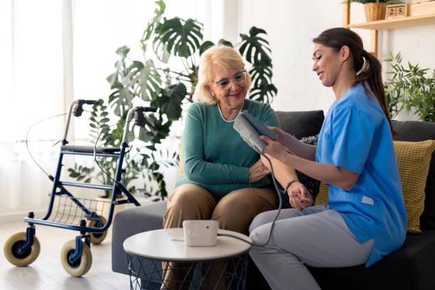 istock Nurse communicating with elderly patient while checking her blood pressure during home visit 1482675353