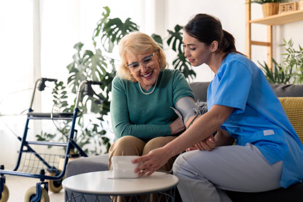 istock Senior woman and nurse using blood pressure machine 1482675390